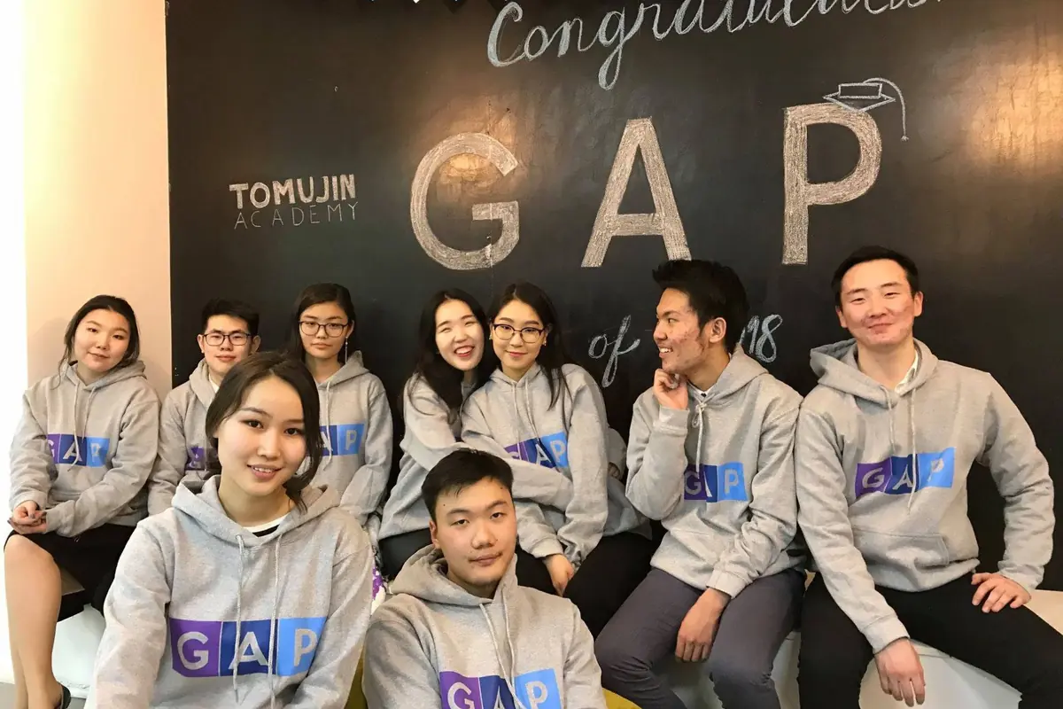 GAP хөтөлбөрийн төгсөгчид Томүжин Академид “Congratulations GAP” самбарын өмнө